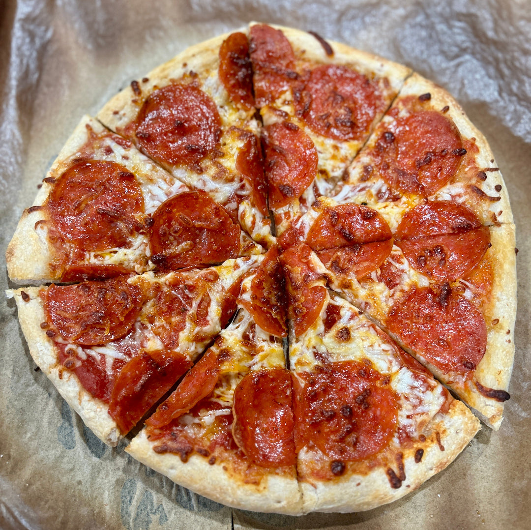 Pepperoni pizza cut into slices on a baking sheet
